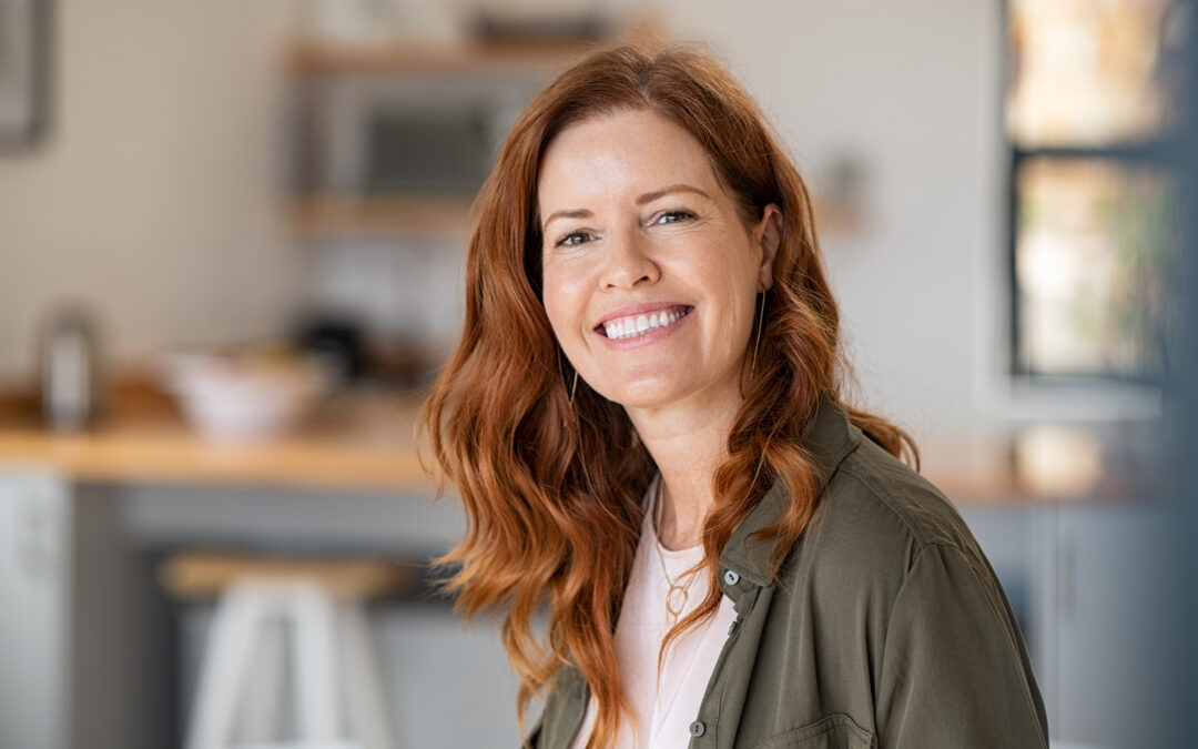 A smiling adult woman with auburn hair who takes Zepbound, tirzepatide.