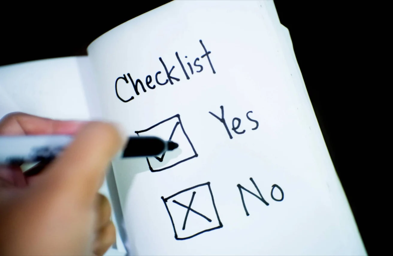A hand is marking a checklist on paper, placing a checkmark next to "Yes" and leaving the box next to "No" unchecked.