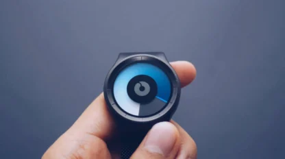 A hand holds a modern, minimalistic wristwatch with a circular, abstract blue and black dial against a plain background.