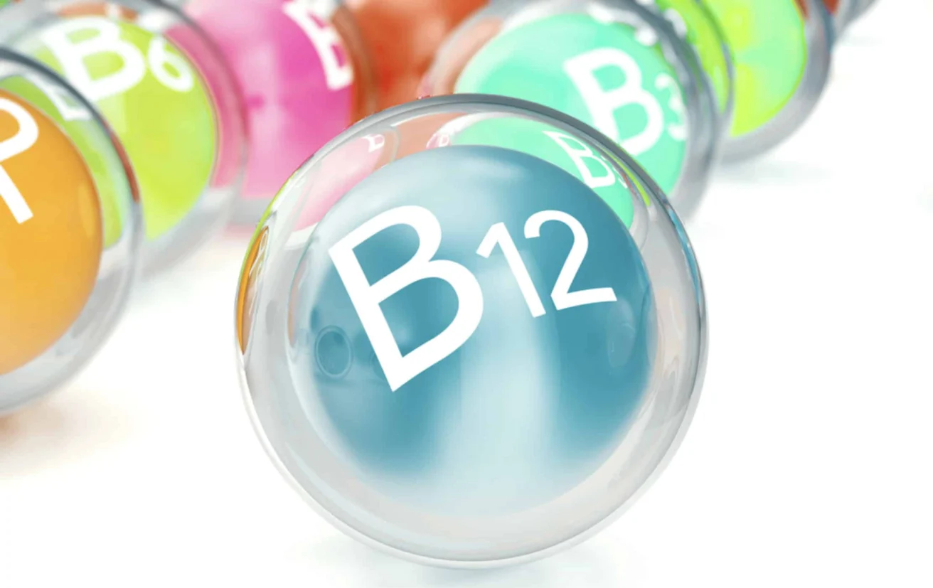 A close-up of a translucent sphere labeled "B12" with other similarly labeled spheres in the background, representing various B vitamins.