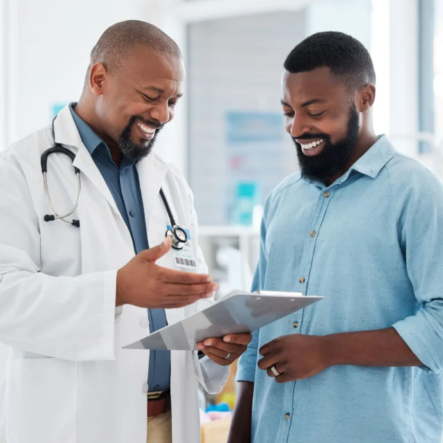 A doctor holding a clipboard and consulting with a patient.