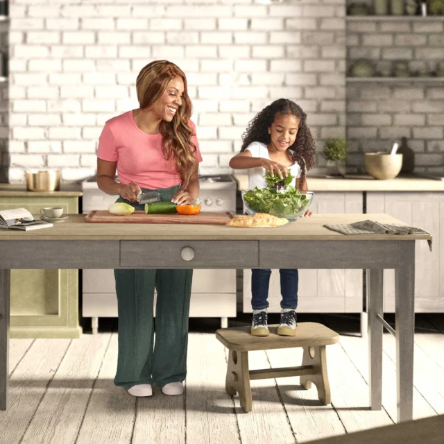 A mother and daughter preparing a salad together.