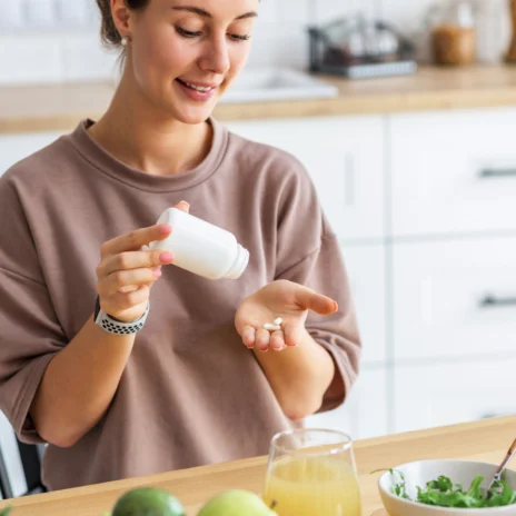 A woman holding a bottle of pills.