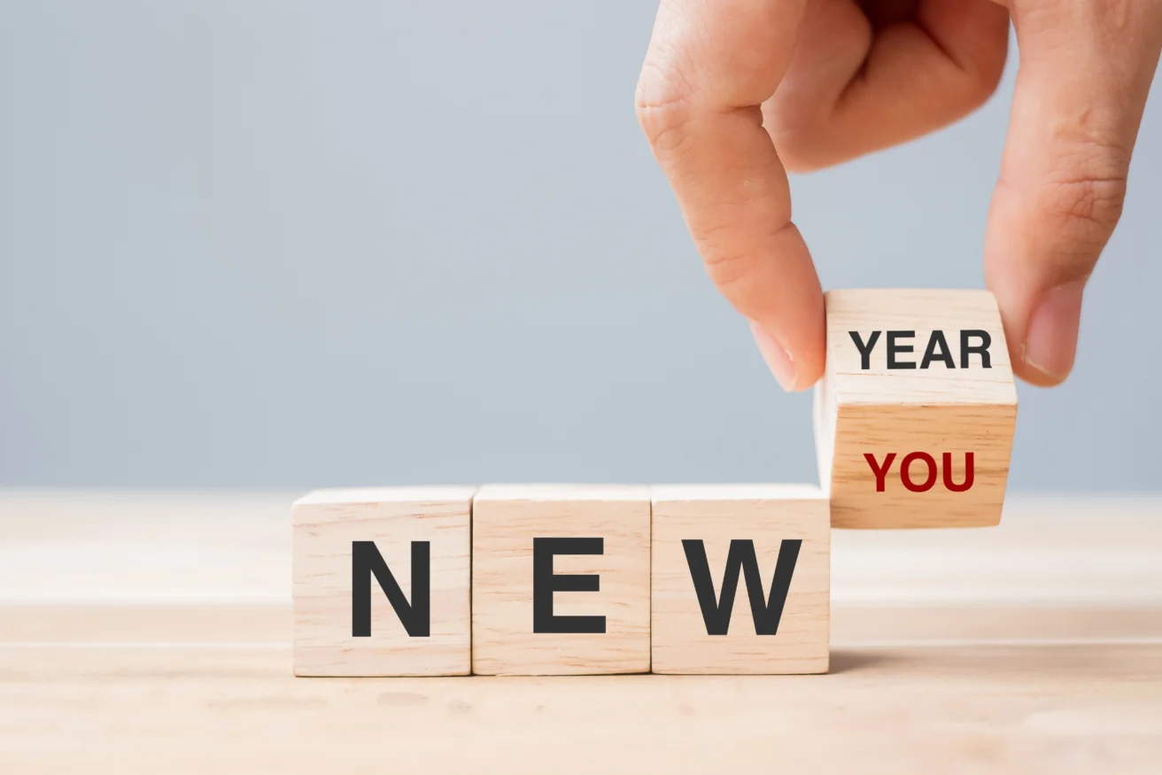 A hand placing a block on a stack of wood blocks.