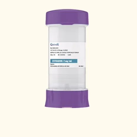 A clear cylindrical prescription container with purple caps at the top and bottom, labeled Estradiol 2 mg/mL, intended for topical use. The label includes dosage instructions and pharmacy information.
