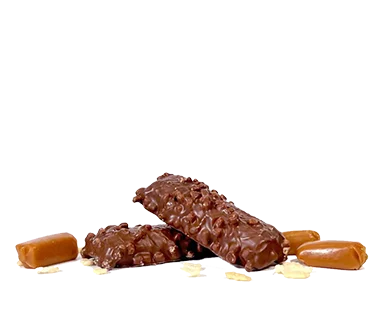 Two chocolate-covered candy bars with a crunchy texture are stacked on each other, surrounded by small caramel pieces and bits of nuts, on a plain white background.