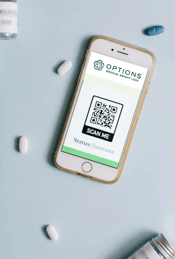 A smartphone displaying a screen with a QR code labeled SCAN ME, the logo Options Medical Weight Loss, and the status Immune. White pills and a vial are scattered on a light blue surface around the phone.